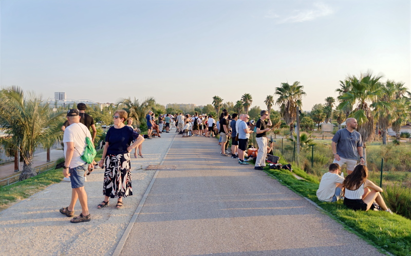 5 - A vibrant pedestrian pathway running through the Turia Gardens with people awaiting the solar eclipse astronomical event in Spain in 2026